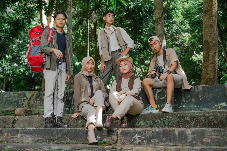 A group of young tourists enjoying a hiking adventure in a lush jungle setting in Lampung, Indonesia.
